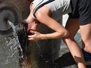 ragazza si rinfresca a una fontana