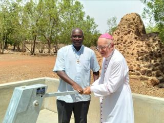 Il vescovo Debernardi davanti a un pozzo in Burkina
