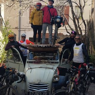 Davide Rivoira con i compagni di viaggio, a sinistra, sul tettuccio della Citroën dell’artista di Arles