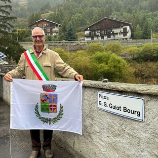 Il sindaco Massimo Marchisio di fianco al cartello della nuova piazza Guiot Bourg