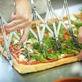 pizza tagliata con un attrezzo a rotella