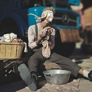 Spettacolo di circo contemporaneo con artista seduto per terra