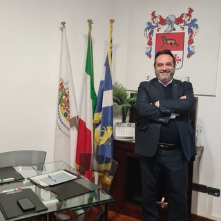 Persona che sorride dietro una scrivania