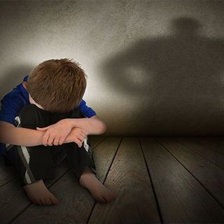 Bambino in difficoltà seduto a terra