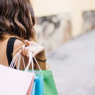donna di spalle con sacchetti da shopping