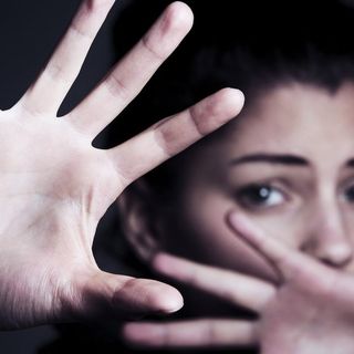 Donna che si protegge con le mani