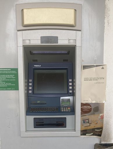 Il bancomat con il foglio che annuncia la chiusura Il bancomat con il foglio che annuncia la chiusura