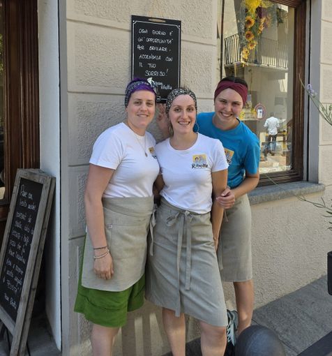 Commercianti cavouresi sotto una lavagnetta con frase motivante