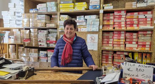 Caterina Ferrero nel suo negozio con in mano uno storico metro in legno per tessuti Caterina Ferrero nel suo negozio con in mano uno storico metro in legno per tessuti