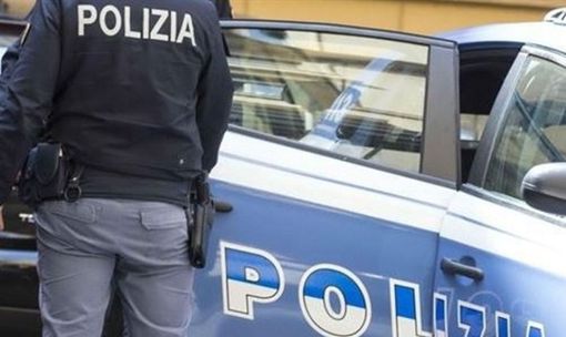 auto della POlizia con agente in piedi vicino a una portiera aperta
