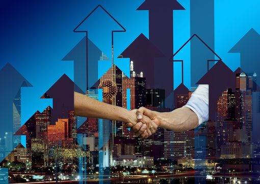 due mani che si stringono sullo sfondo di grattacieli illuminati e frecce due mani che si stringono sullo sfondo di grattacieli illuminati e frecce