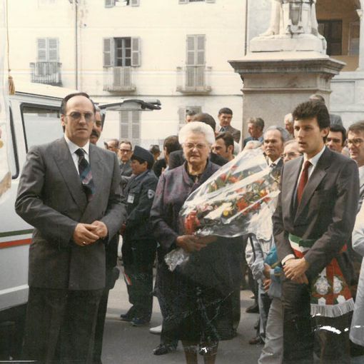 Il presidente di un tempo Aldo Fassino (accanto al labaro associativo), al centro la madrina Amalia Galetto e a lato il sindaco Emilio Bolla in piazza Santa Maria per l'inaugurazione della sede