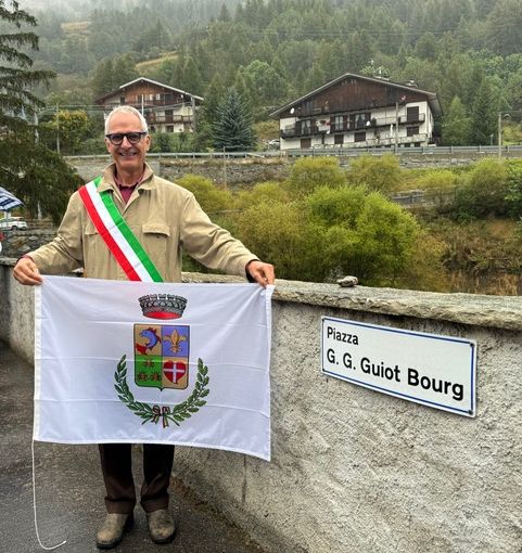 Il sindaco Massimo Marchisio di fianco al cartello della nuova piazza Guiot Bourg