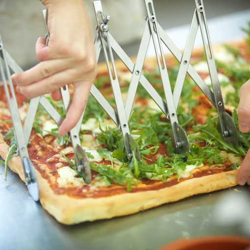 pizza tagliata con un attrezzo a rotella