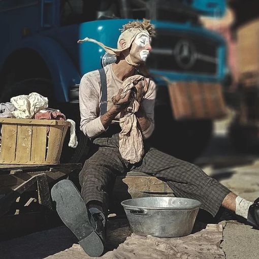 Spettacolo di circo contemporaneo con artista seduto per terra