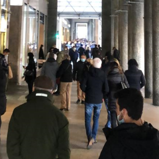 persone sotto i portici in via Roma