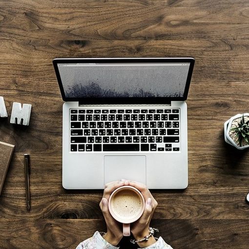 mani intorno a una tazza e un pc