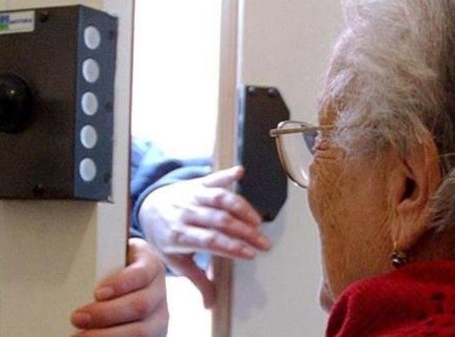 donna anziana con mani di estranei che entrano dalla porta
