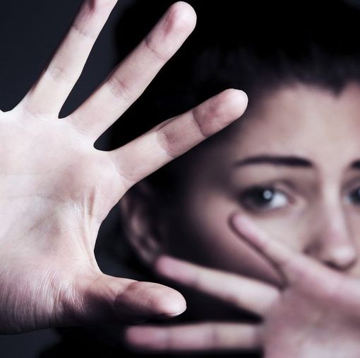 Donna che si protegge con le mani