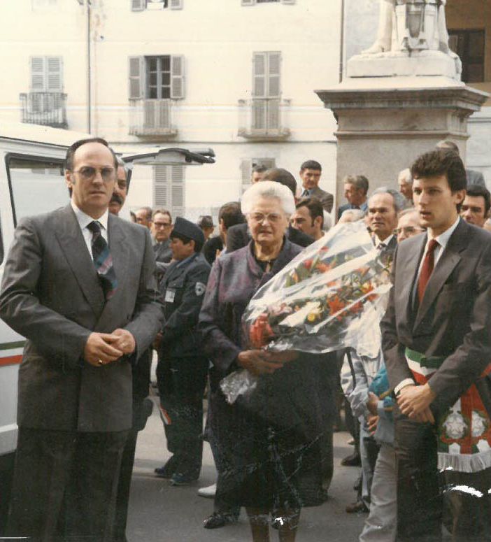 Il presidente di un tempo Aldo Fassino (accanto al labaro associativo), al centro la madrina Amalia Galetto e a lato il sindaco Emilio Bolla in piazza Santa Maria per l'inaugurazione della sede