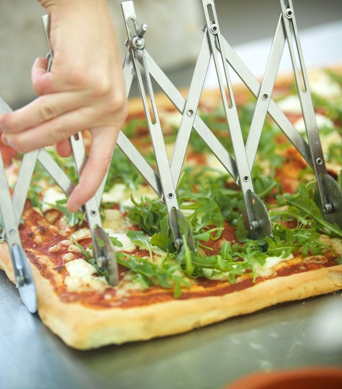 pizza tagliata con un attrezzo a rotella