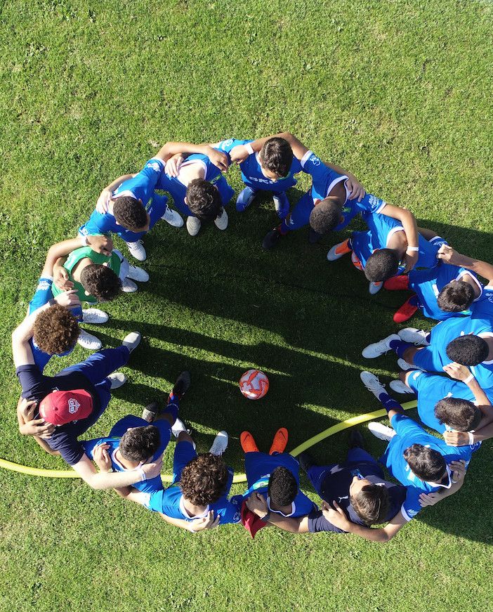ragazzi abbracciati in mezzo al campo di calcio