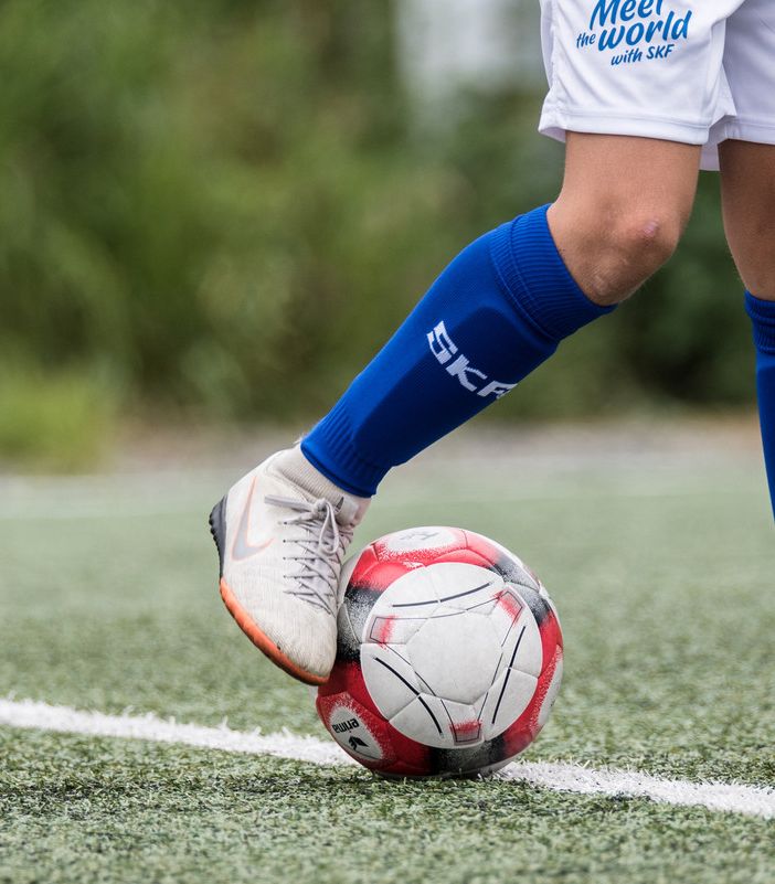 Gambe di un calciatore che toccano un pallone