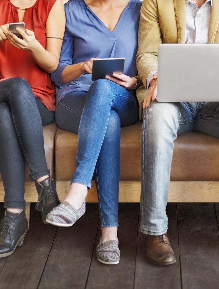Persone sedute alle prese con dispositivi digitali