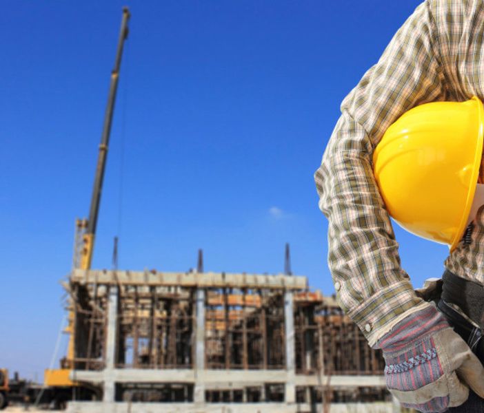 cantiere edile e uomo con caschetto protettivo