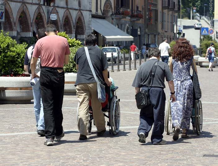 Persone in carrozzina con accompagnatori