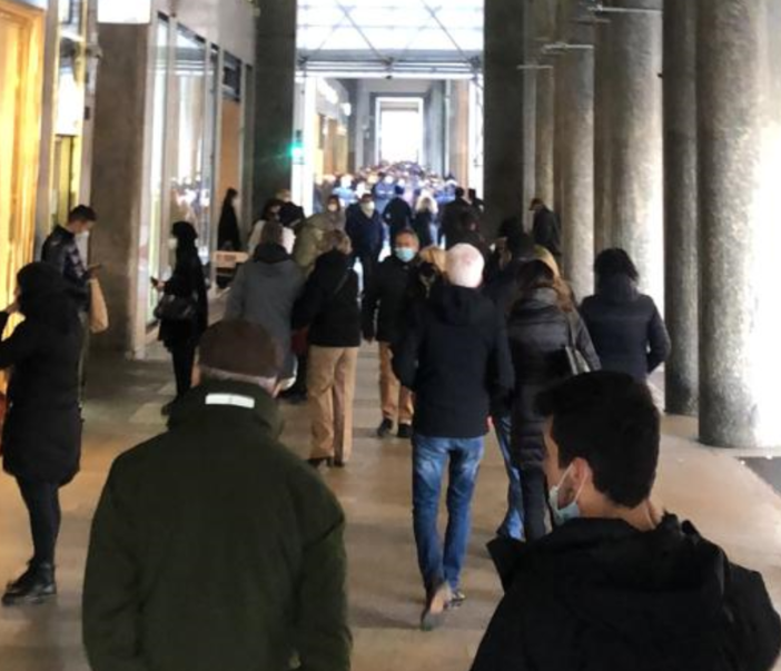 persone sotto i portici in via Roma