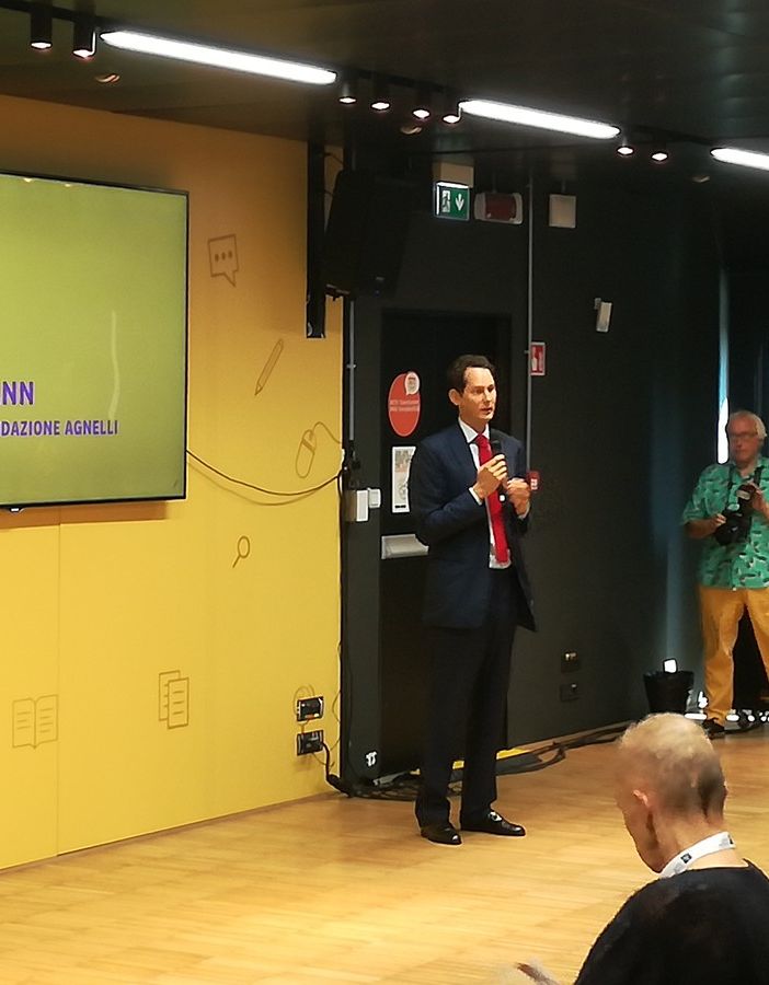 John Elkann davanti a un megaschermo