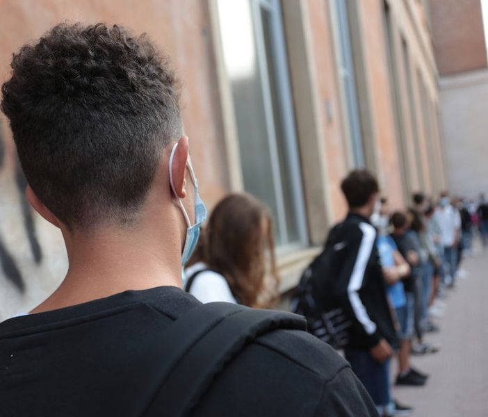 ragazzi in coda all'ingresso a scuola