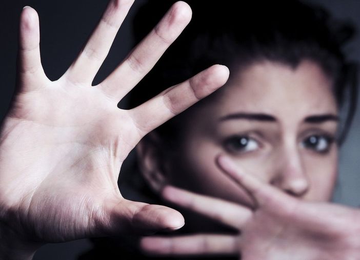 Donna che si protegge con le mani