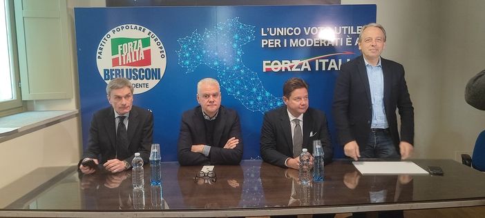 Persone davanti a simboli elettorali