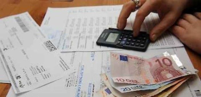 persona che fa calcoli con delle bollette sul tavolo persona che fa calcoli con delle bollette sul tavolo