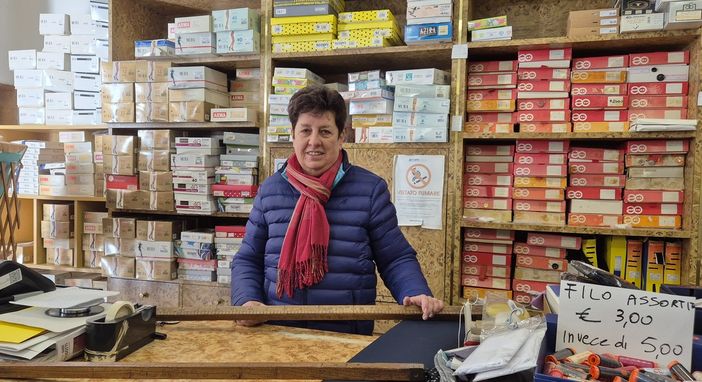 Caterina Ferrero nel suo negozio con in mano uno storico metro in legno per tessuti Caterina Ferrero nel suo negozio con in mano uno storico metro in legno per tessuti