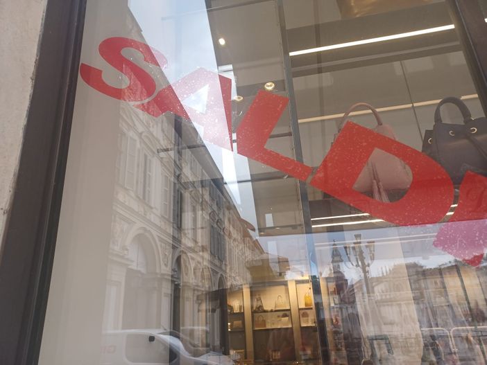 Vetrina con la scritta "Saldi" in diagonale e in rosso Vetrina con la scritta "Saldi" in diagonale e in rosso