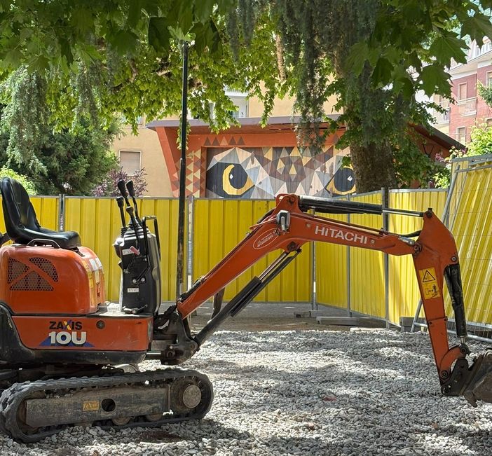 L’escavatore in piazza Muston con dietro il gufo