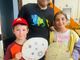 Roberto Pino con due dei bambini che hanno realizzato le decorazioni lunari per la nuova festa perosina