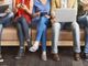 Persone sedute alle prese con dispositivi digitali