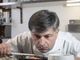Cuoco che assaggia da una pentola con un cucchiaio di legno