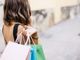 donna di spalle con sacchetti da shopping