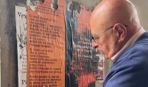 Munito di spruzzino e raschietto: consigliere comunale elimina i manifesti abusivi