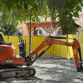 L’escavatore in piazza Muston con dietro il gufo L’escavatore in piazza Muston con dietro il gufo