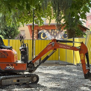 L’escavatore in piazza Muston con dietro il gufo
