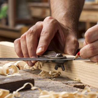 Artigiano al lavoro con mano che lavora il legno