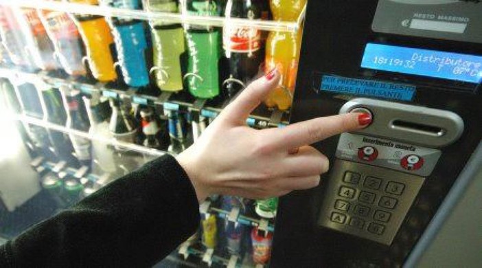 distributore automatico con mano che seleziona prodotto